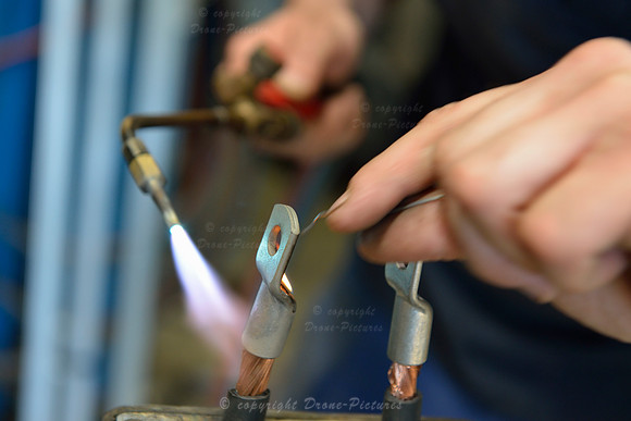 Man brazing wires at garage